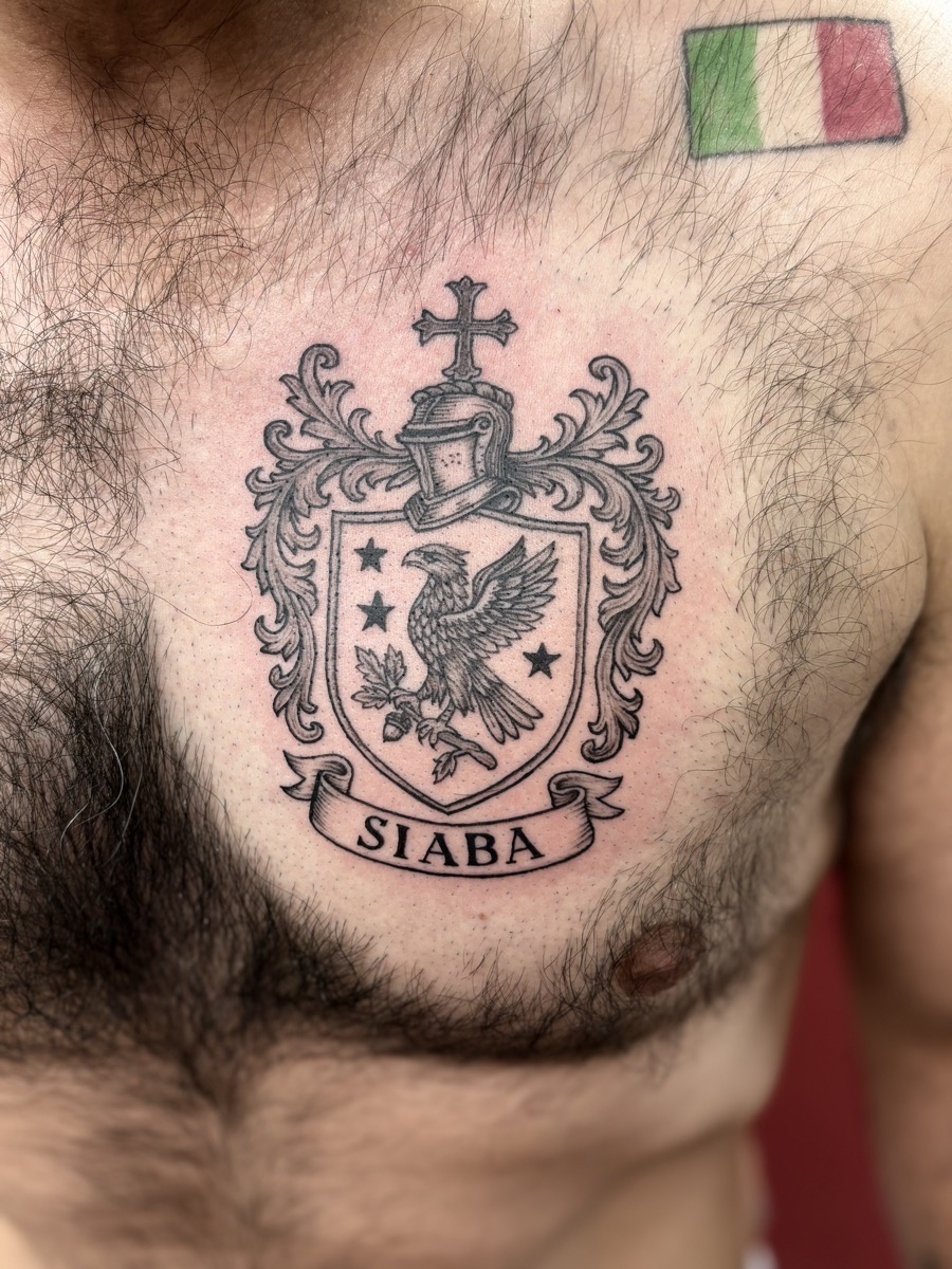 Italian family crest chest tattoo with eagle, shield, cross, and Siaba banner with Italian flag