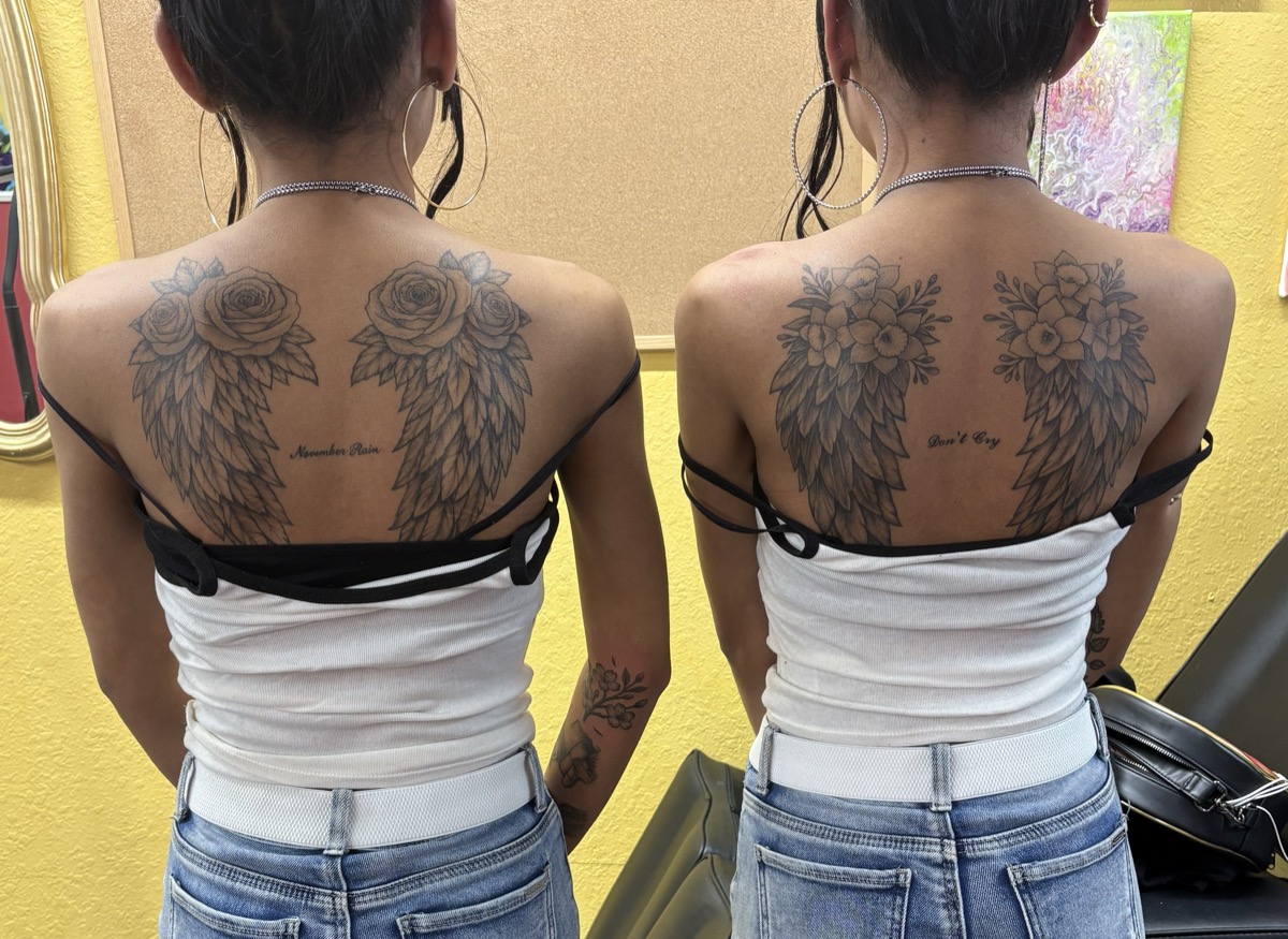 Matching angel wings back tattoos on two people with roses and floral accents